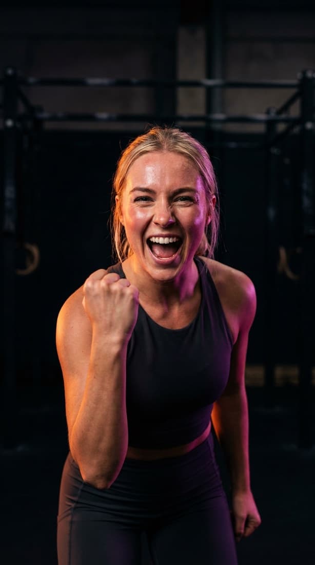 Athlete celebrating a finished set, lit in orange and purple